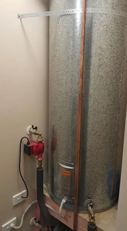 Hot water cylinder and valves installed in a cupboard