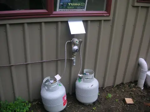 LPG gas bottles and regulator installed on the side of a building